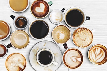 Kaffee-Tassen mit verschiedenen Kaffeesorten von oben fotografiert.